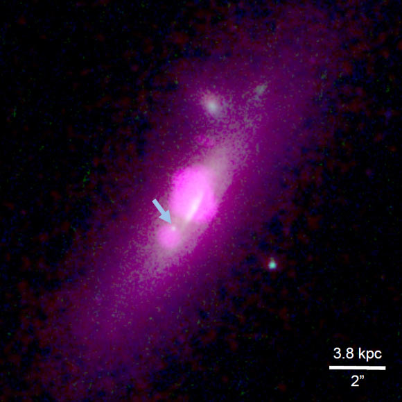 Composite image from the NASA/ESA Hubble Space Telescope and NASA’s Chandra X-ray Observatory shows the galaxy SDSS J112659.54+294442.8. The arrow points to the galactic core fragment that fisioned from the galaxy's central core. Image credit: NASA / ESA / Hubble Team / Chandra Team / Julia M. Comerford et al.